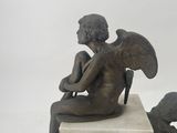 a statue of an angel sitting on top of a clock
