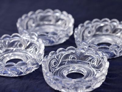four clear glass bowls with swirl designs on a black surface