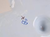 a white vase with a blue anchor on it