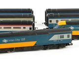 three model trains sitting next to each other on a white surface