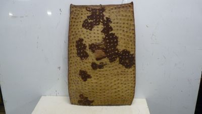 un sac marron et noir posé sur une table blanche