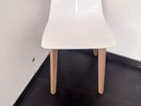 une chaise blanche posée dans un coin d'une pièce
