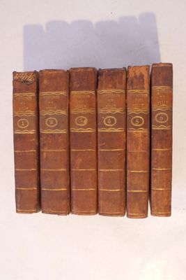 plusieurs vieux livres sont alignés sur une surface blanche