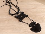 a black object on a wooden floor with a black cord