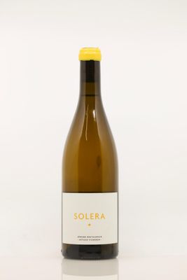 la bouteille de vin blanc est posée sur une surface blanche