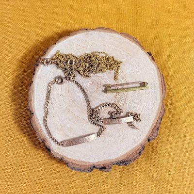 a piece of wood with a necklace and a pair of scissors on it