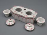 une boîte blanche et rouge contenant quatre tasses et une soucoupe