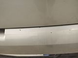 a close up of a white car with a denting bumper