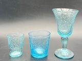 three glasses and a cup sitting on a table
