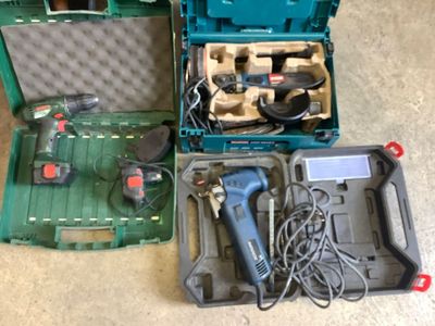 a green case with tools inside of it on the floor