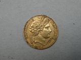 a close up of a gold coin on a white surface