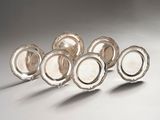 six silver plated dishes are lined up on a white surface