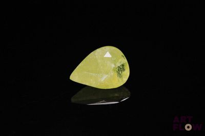 une pierre de quartz jaune posée sur une surface noire