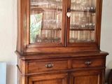 un vaisselier en bois avec des portes en verre dans une pièce