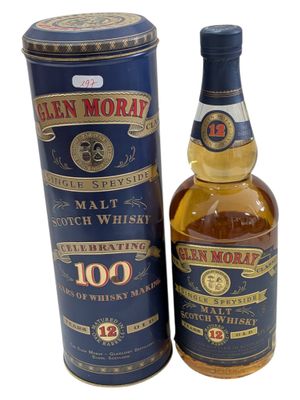 a bottle of glen moray 10 years old scotch whisky next to a canister