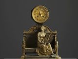 statue en bronze représentant une femme assise sur un banc, avec une horloge au-dessus de sa tête
