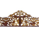 une grande tête de lit en or richement décorée, sur laquelle figure une croix