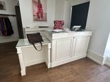 a desk with a purse on it in the corner of a room
