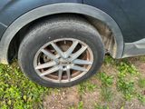 a black car with a flat tire on the grass
