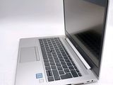 a silver laptop computer sitting on a white surface