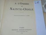 un livre ouvert posé sur un lit recouvert de feuilles de papier