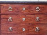 a wooden chest of drawers with a marble top