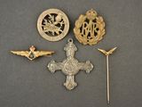 three badges and a pin on a gray surface