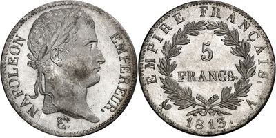 a silver coin with a woman ' s head and laurels on it