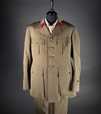an army uniform on a mannequin stand against a black background