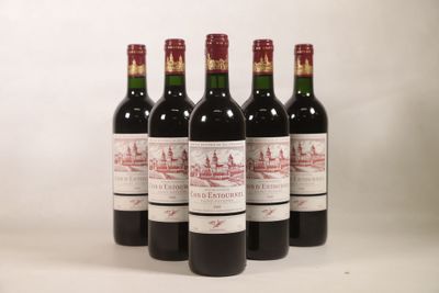 quatre bouteilles de vin sont alignées sur une surface blanche