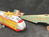 two toy airplanes sitting next to each other on a black surface