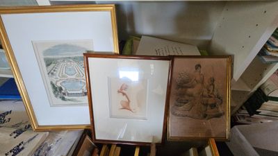 deux photos encadrées posées sur une table, à côté d'une pile de livres