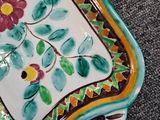 a plate with a flower design on it on the floor
