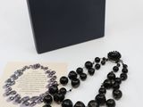 a black rosary with a card and a black box