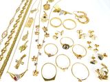 a lot of gold jewelry on a white surface