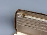 someone is holding a silver purse with a zipper on it