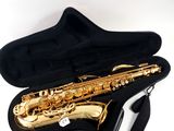 a gold saxophone in a black case on a white background