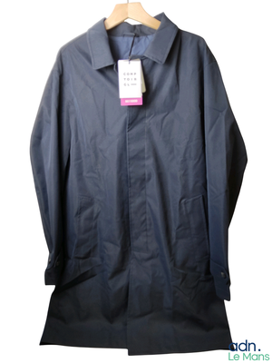 imperméable bleu marine avec une étiquette rose sur un cintre, sur fond blanc