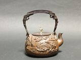 a tea pot with a handle and a handle on it