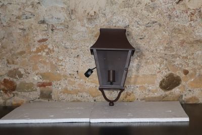 une lampe fixée sur le côté d'un mur de briques