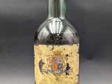Une vieille bouteille de « Brandy Extra » est posée sur une table