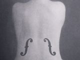 a black and white photo of a woman with a violin tattoo on her back