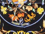 a black table cloth with a picture of a bird and flowers on it