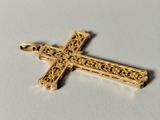 a close up of a gold cross on a white surface