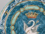 a blue plate with a swan and a crown on it