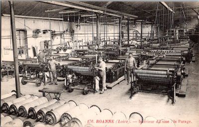 photographie en noir et blanc d'une usine où des ouvriers travaillent sur des machines