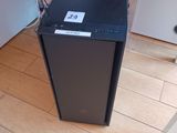 a black computer sitting on a wooden floor in a room