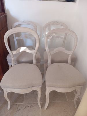 trois chaises blanches placées les unes à côté des autres sur un sol carrelé