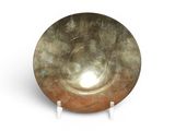 a large metal bowl on a stand on a white surface