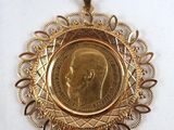 a close up of a gold medal with a picture of a man on it